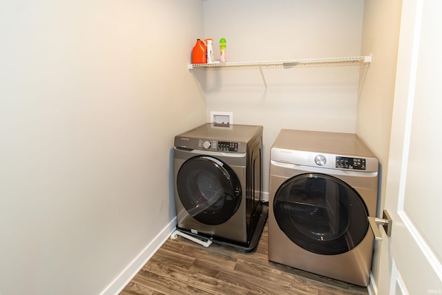 laundry room with washer and dryer, laundry area, wood finished floors, and baseboards