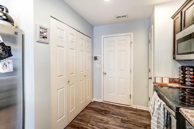 doorway to outside with dark wood finished floors, visible vents, and baseboards