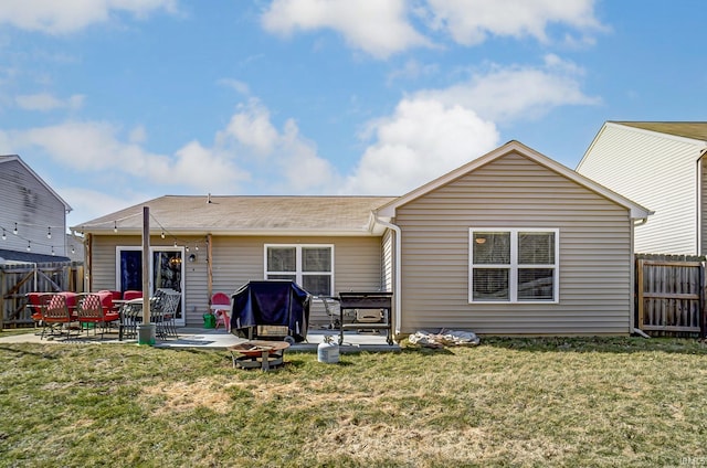 back of property with a yard, fence, and a patio area