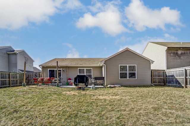 rear view of property featuring a fenced backyard, a lawn, and a patio