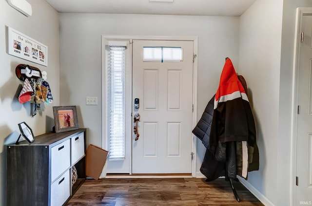 entrance foyer with a wealth of natural light, dark wood-style floors, and a wall unit AC