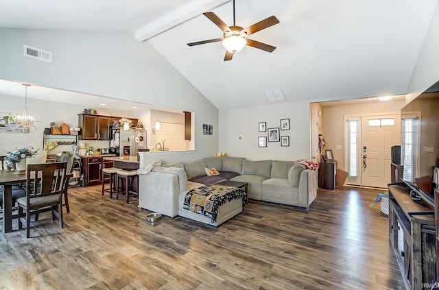 living area with wood finished floors, visible vents, high vaulted ceiling, beamed ceiling, and ceiling fan with notable chandelier