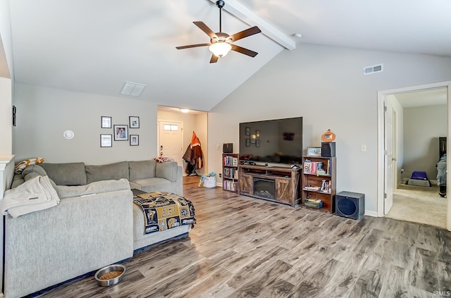 living room with wood finished floors, visible vents, a fireplace, ceiling fan, and beamed ceiling