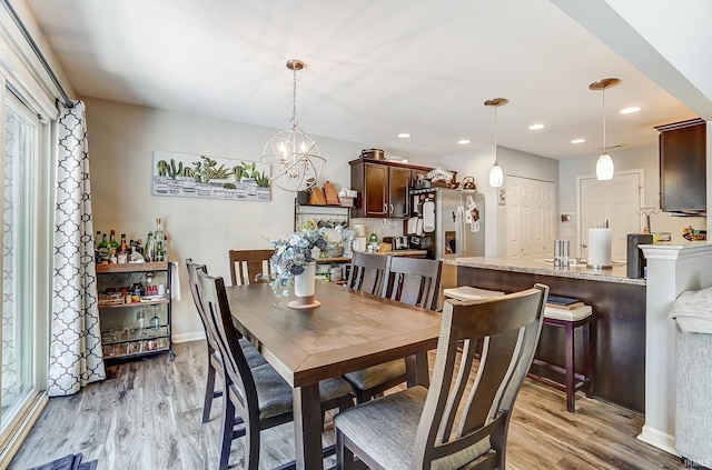 dining room with recessed lighting, baseboards, an inviting chandelier, and light wood-style flooring