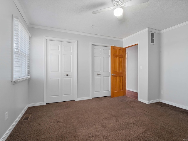 unfurnished bedroom featuring visible vents, carpet flooring, a textured ceiling, and crown molding