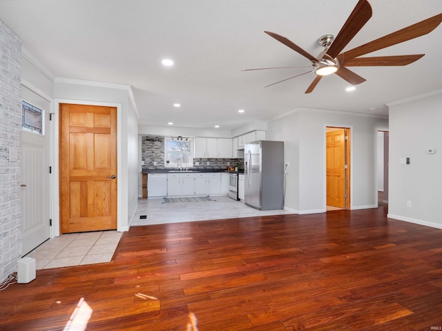 unfurnished living room with a ceiling fan, light wood-style flooring, recessed lighting, a sink, and crown molding