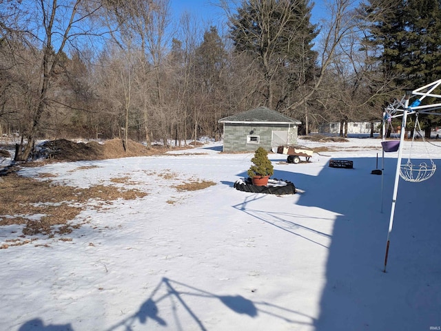 yard layered in snow featuring an outdoor structure