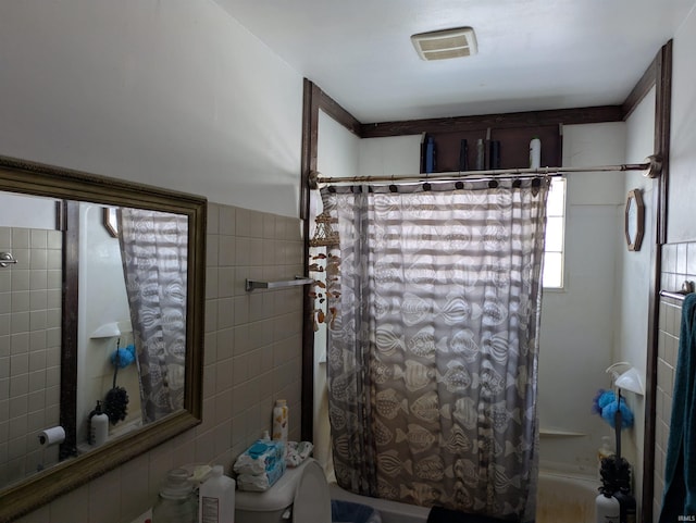 full bathroom featuring tile walls, shower / tub combo, and visible vents