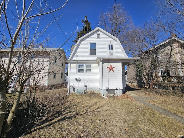 back of house featuring a gambrel roof