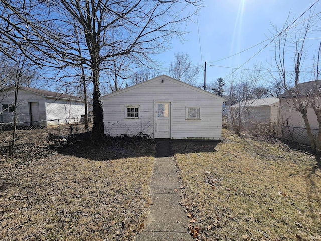 back of property featuring an outbuilding and fence