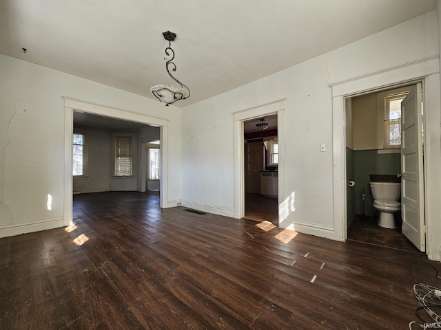 unfurnished dining area featuring visible vents, baseboards, and dark wood-style flooring