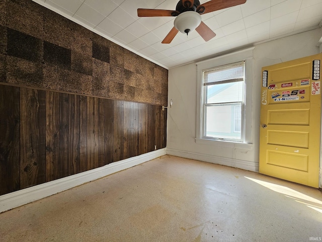 empty room with wood walls and ceiling fan