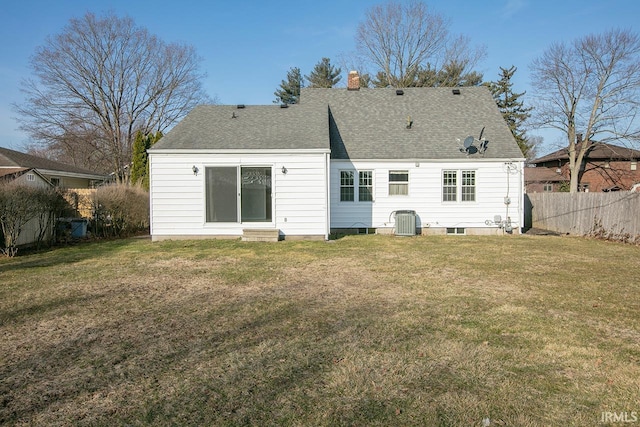 rear view of house featuring central AC unit, fence, a lawn, and a chimney