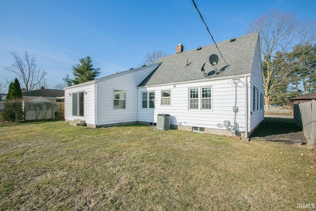 back of property featuring a lawn, fence, cooling unit, a shingled roof, and a chimney