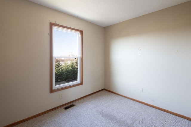 empty room with visible vents, baseboards, and carpet