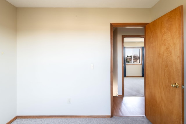 empty room featuring baseboards and carpet floors