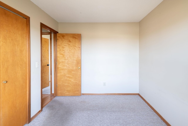 unfurnished bedroom with baseboards and carpet