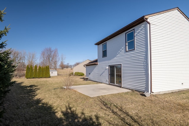 rear view of house with a lawn and a patio