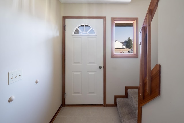 interior space featuring light tile patterned floors, stairway, and baseboards