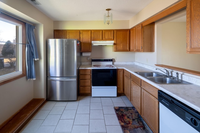 kitchen with under cabinet range hood, electric range oven, freestanding refrigerator, white dishwasher, and a sink