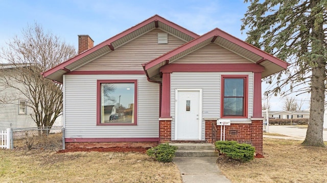 bungalow-style home with fence and a chimney