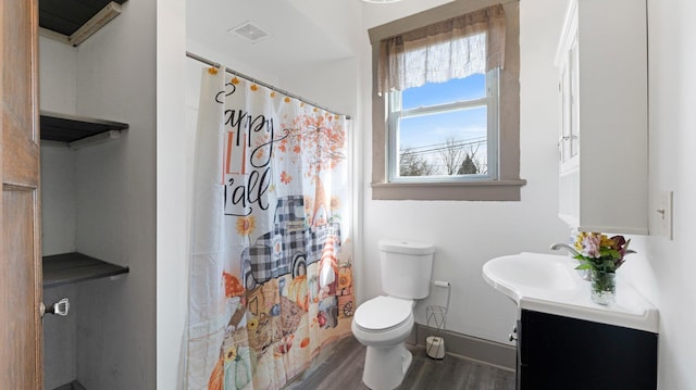 bathroom featuring vanity, wood finished floors, visible vents, baseboards, and toilet