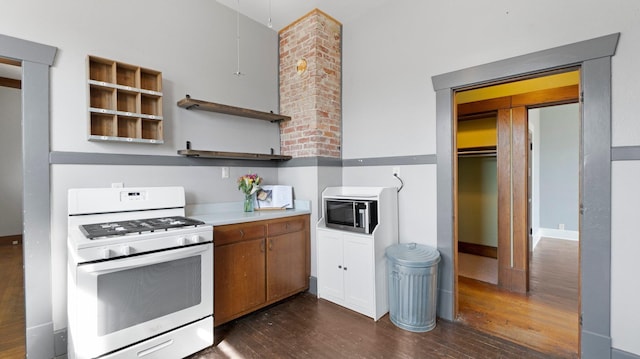 kitchen featuring stainless steel microwave, dark wood-type flooring, gas range gas stove, light countertops, and open shelves