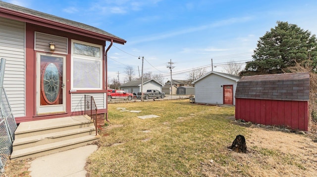 view of yard with an outbuilding, entry steps, a storage unit, and fence