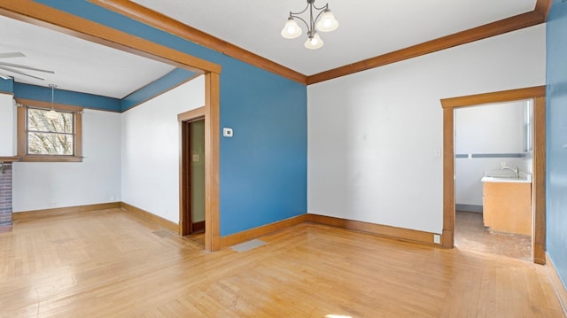 unfurnished living room with baseboards, wood finished floors, visible vents, and a chandelier