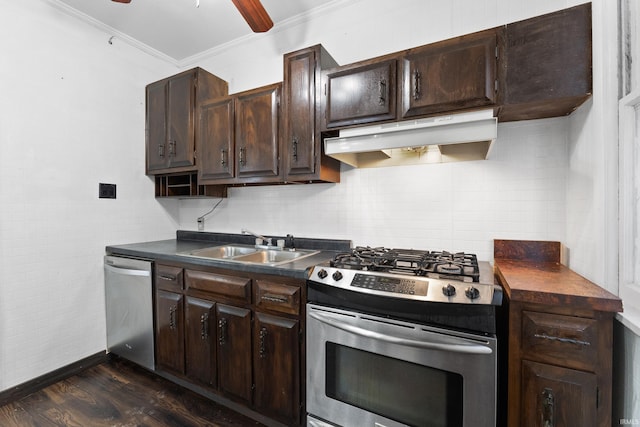 kitchen with under cabinet range hood, stainless steel appliances, dark countertops, and a sink