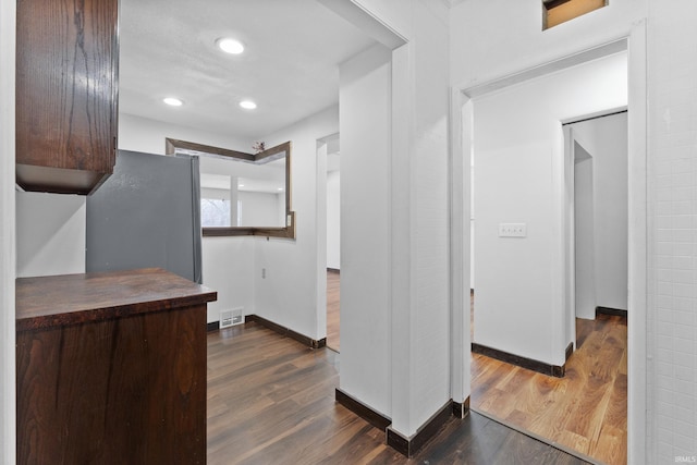 kitchen with visible vents, baseboards, recessed lighting, freestanding refrigerator, and dark wood-style floors