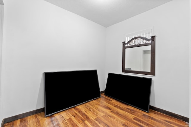 unfurnished room featuring wood finished floors and baseboards