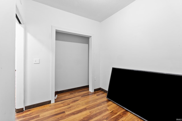 bedroom with baseboards and wood finished floors