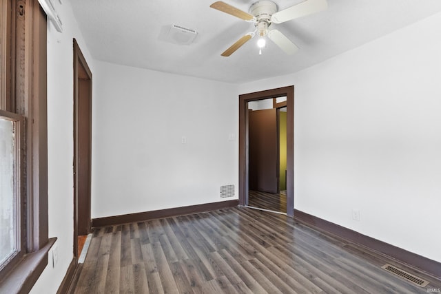 unfurnished bedroom with dark wood-style floors, visible vents, and baseboards