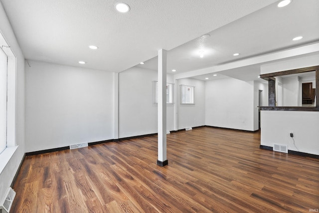 basement featuring visible vents, recessed lighting, and wood finished floors