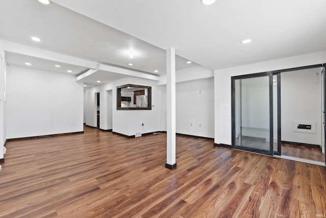 unfurnished living room with recessed lighting, baseboards, and wood finished floors