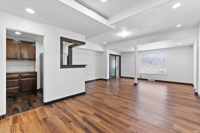 unfurnished living room with visible vents, recessed lighting, wood finished floors, and baseboards