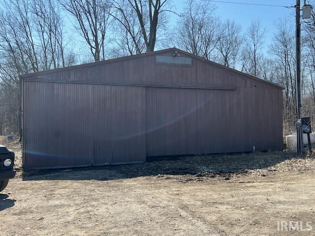 view of side of home featuring a garage and an outbuilding