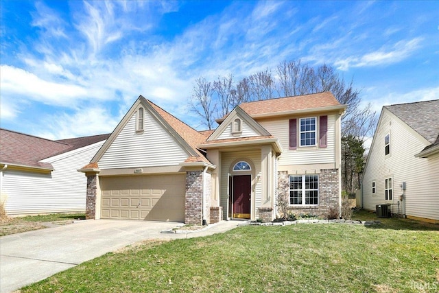 traditional-style house with brick siding, driveway, an attached garage, and a front lawn