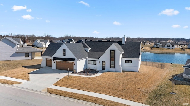 modern inspired farmhouse featuring a residential view, concrete driveway, a water view, and a shingled roof