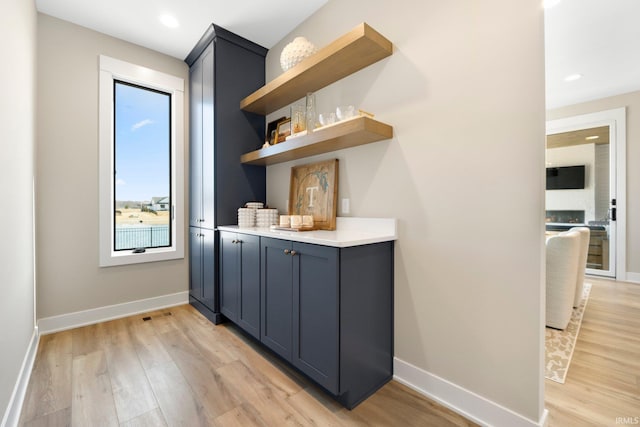 bar featuring recessed lighting, baseboards, and light wood-style floors