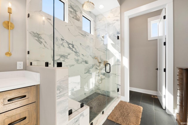 full bathroom featuring vanity, tile patterned floors, baseboards, and a marble finish shower