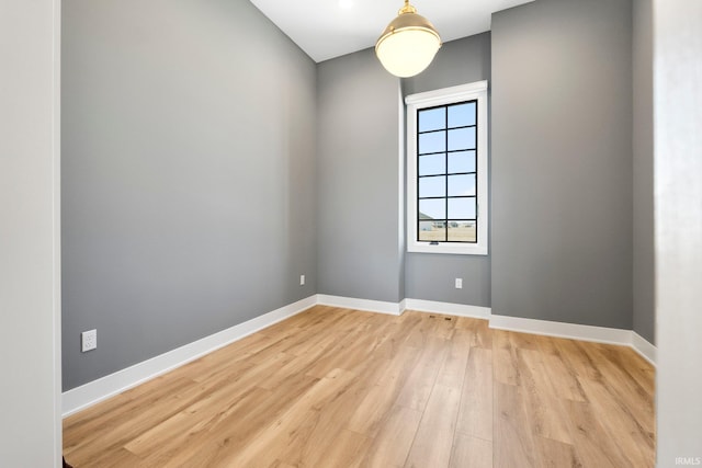 empty room featuring light wood-type flooring and baseboards