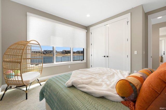 carpeted bedroom featuring a closet, recessed lighting, and baseboards