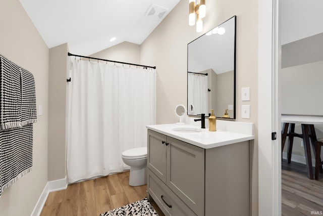 bathroom featuring visible vents, toilet, vaulted ceiling, wood finished floors, and vanity