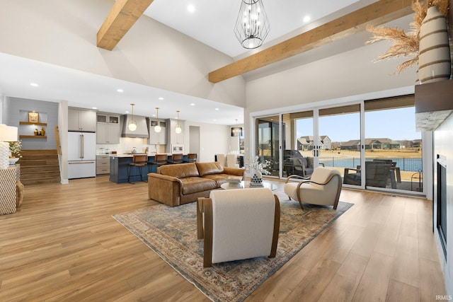 living area with beamed ceiling, recessed lighting, light wood-type flooring, and a towering ceiling