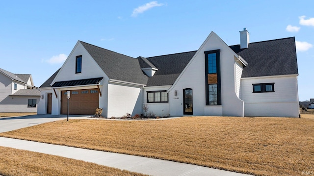 modern inspired farmhouse with a front lawn, concrete driveway, roof with shingles, a chimney, and a garage