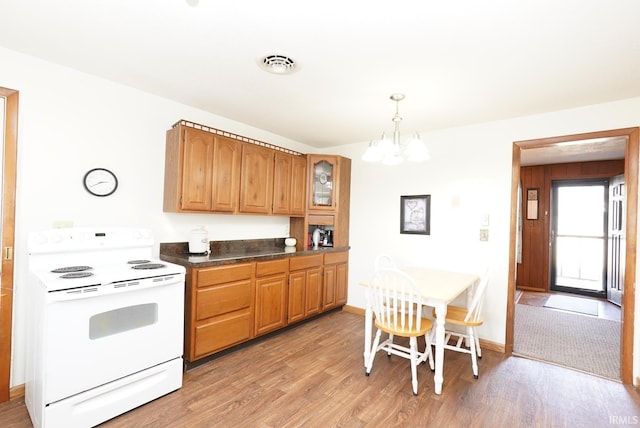 kitchen featuring visible vents, white electric stove, light wood-style floors, dark countertops, and a chandelier