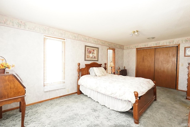 carpeted bedroom featuring a closet and baseboards