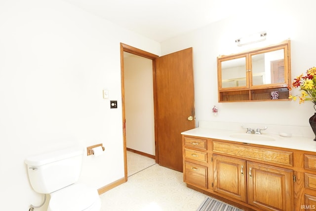 bathroom featuring baseboards, toilet, and vanity